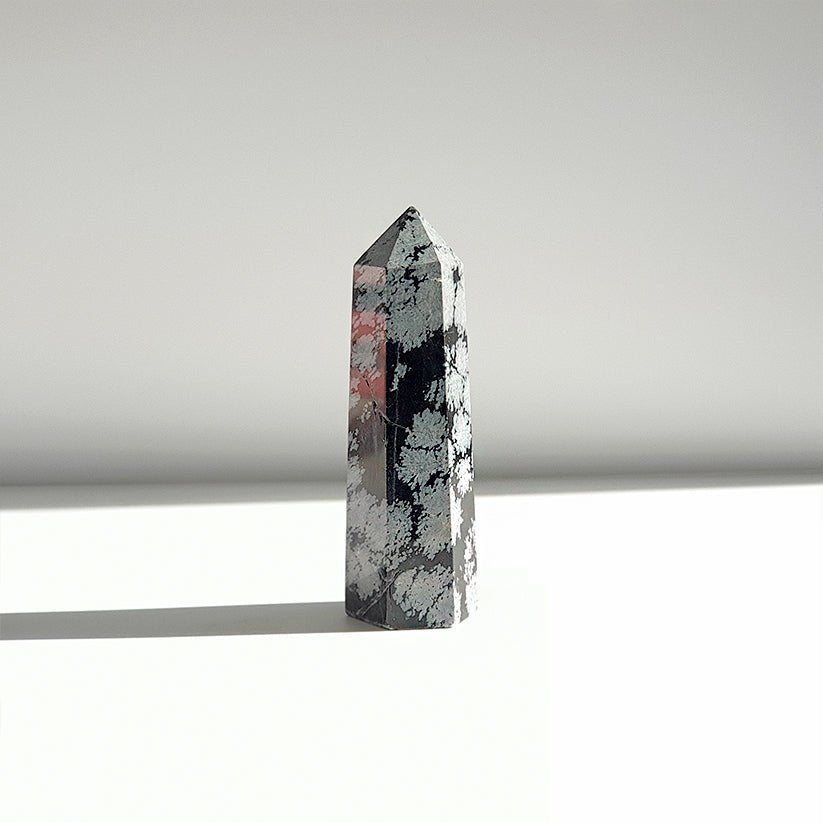 Punta de obsidiana Nevada de la marca Mystical Tienda, usada para protección y equilibrio, con forma puntiaguda y superficie brillante.