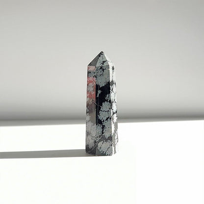 Punta de obsidiana Nevada de la marca Mystical Tienda, usada para protección y equilibrio, con forma puntiaguda y superficie brillante.
