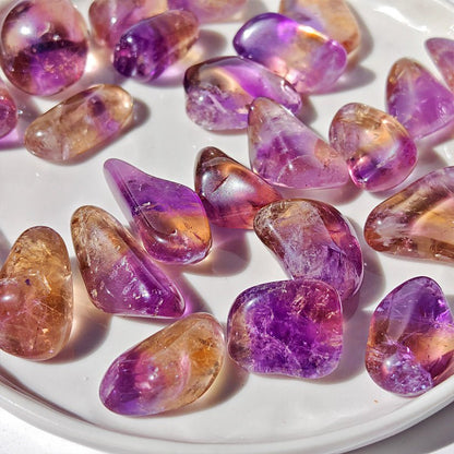 Rodado de ametrino de la marca Mystical Tienda, muestra detalles y colores vibrantes del cristal en una superficie.