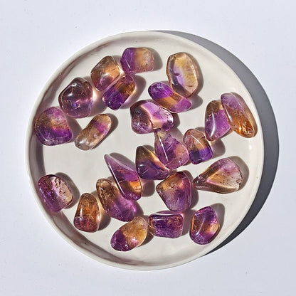 Rodado de ametrino de Mystical Tienda, piedra semipreciosa con tonos morados y dorados, muestra detalles y brillo en la superficie.