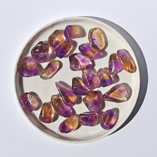 Rodado de ametrino de Mystical Tienda, piedra semipreciosa con tonos morados y dorados, muestra detalles y brillo en la superficie.