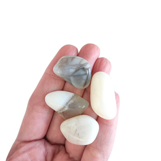 Rodado de ópalo blanco de Mystical Tienda, muestra superficie lisa y brillante con tonos blancos y azules suaves.