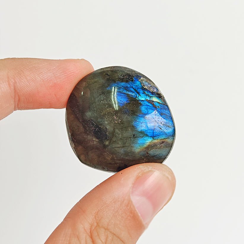 Rodado Palm Stone de labradorita de la marca Mystical Tienda, muestra superficie pulida con reflejos iridiscentes y tonos azules y verdes
