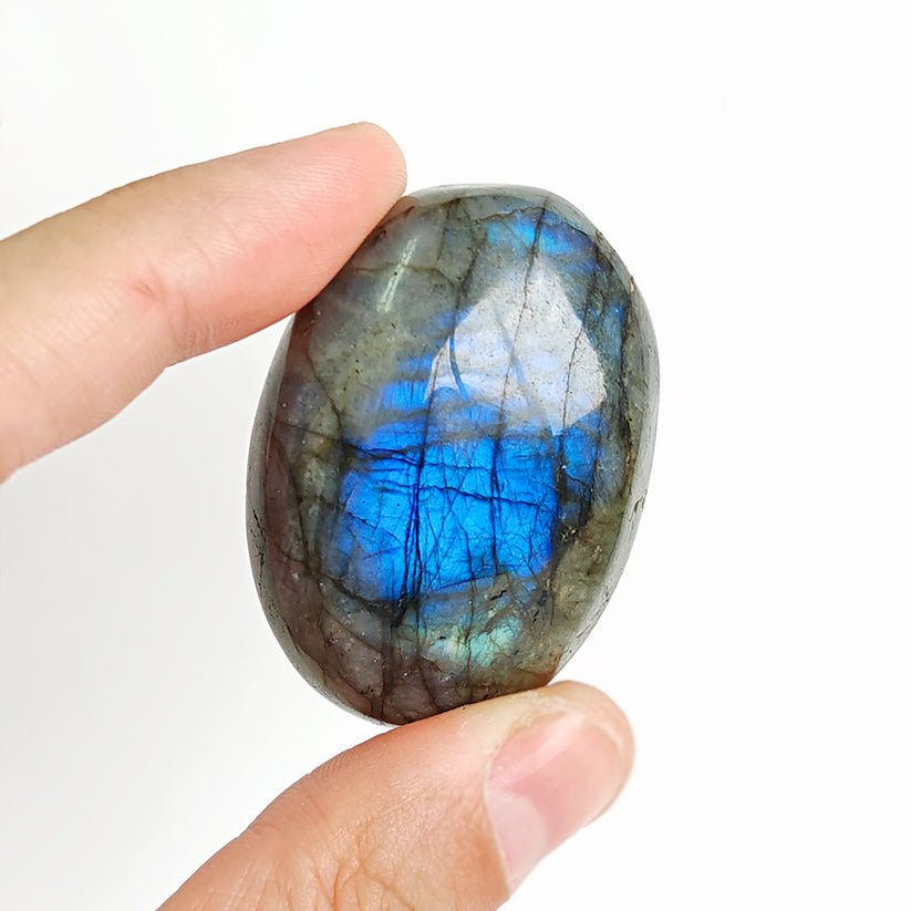 Rodado palm stone de labradorita con tonos azules y grises, de tamaño compacto y superficie pulida, de la marca Mystical Tienda.