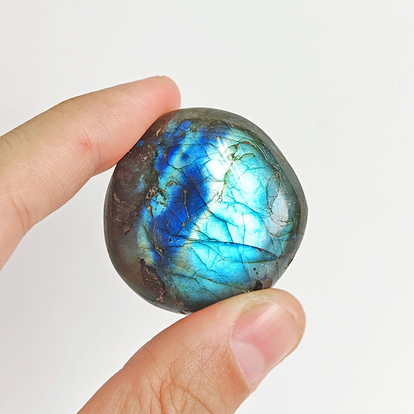 Rodado Palm Stone de labradorita con brillo azul y verde, de tamaño compacto y forma ovalada, de la marca Mystical Tienda.