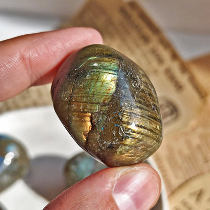 Rodado de labradorita edición imperfecta de Mystical Tienda, piedra semipreciosa con destellos azules y verdes en forma redonda.
