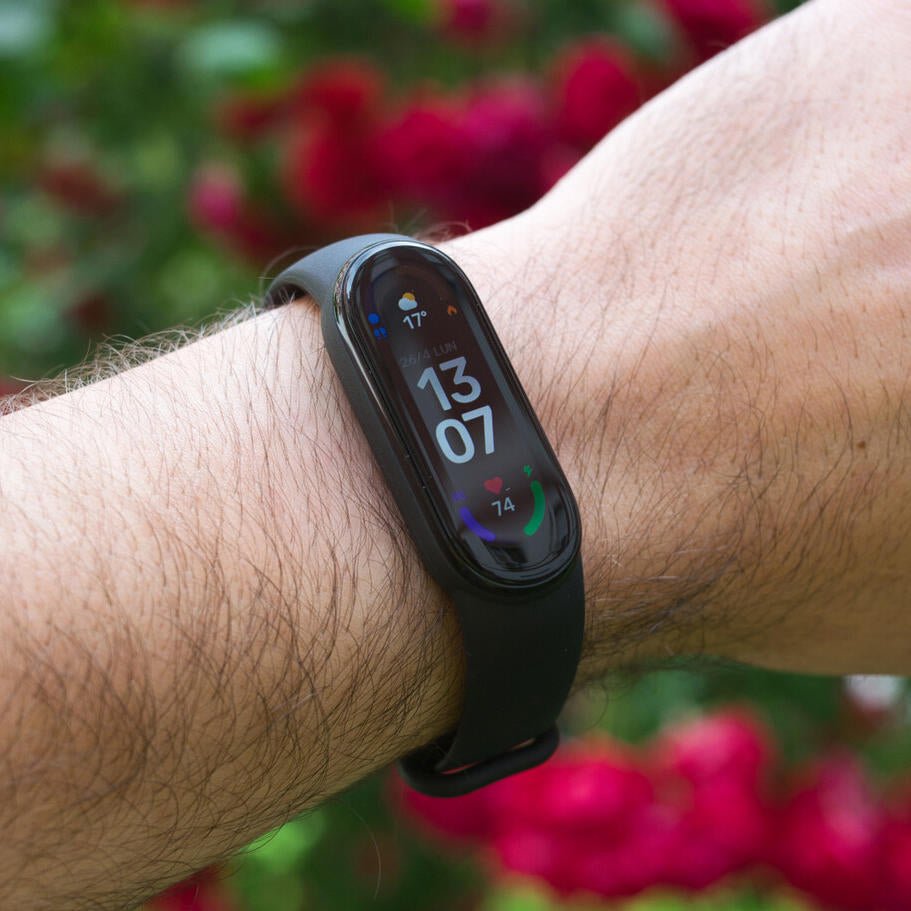 Pulsera inteligente Innovagizmo Smartband 6 WT-146 con pantalla y sensores en una mano, color negro, diseñada para monitorear actividad física.