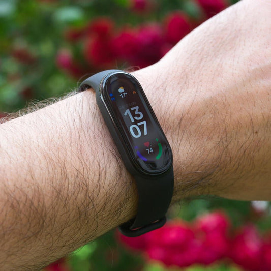 Pulsera inteligente Innovagizmo Smartband 6 WT-146 con pantalla y sensores en una mano, color negro, diseñada para monitorear actividad física.