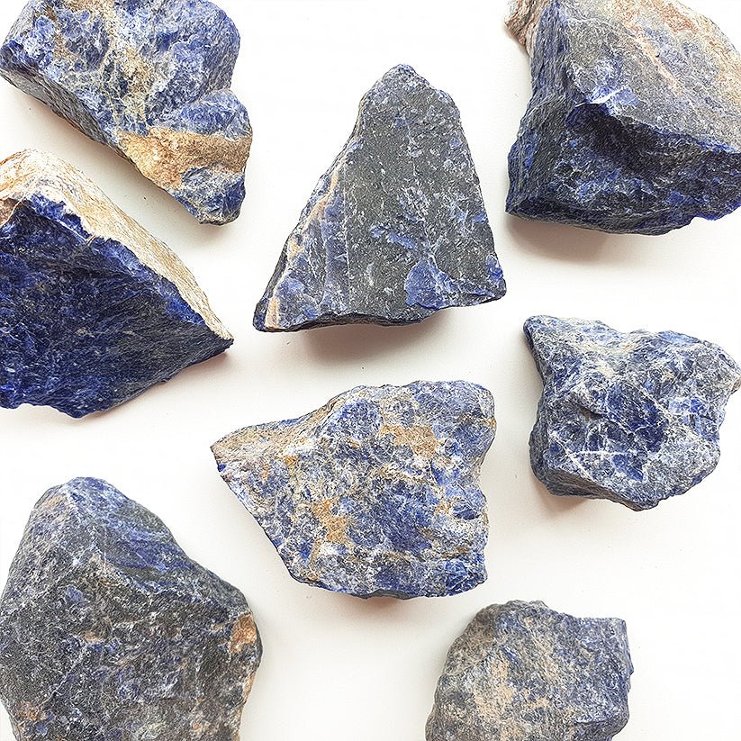 Muestra de piedra de sodalita en bruto, cristal natural de color azul con vetas blancas, en forma de mineral sin pulir.