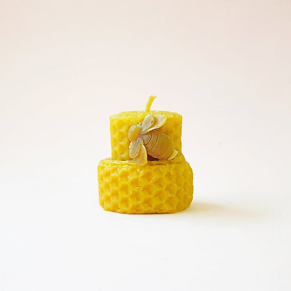 Vela de miel de tamaño mediano con aroma dulce, presentada en un vaso transparente, perfecta para crear ambiente cálido y relajante.